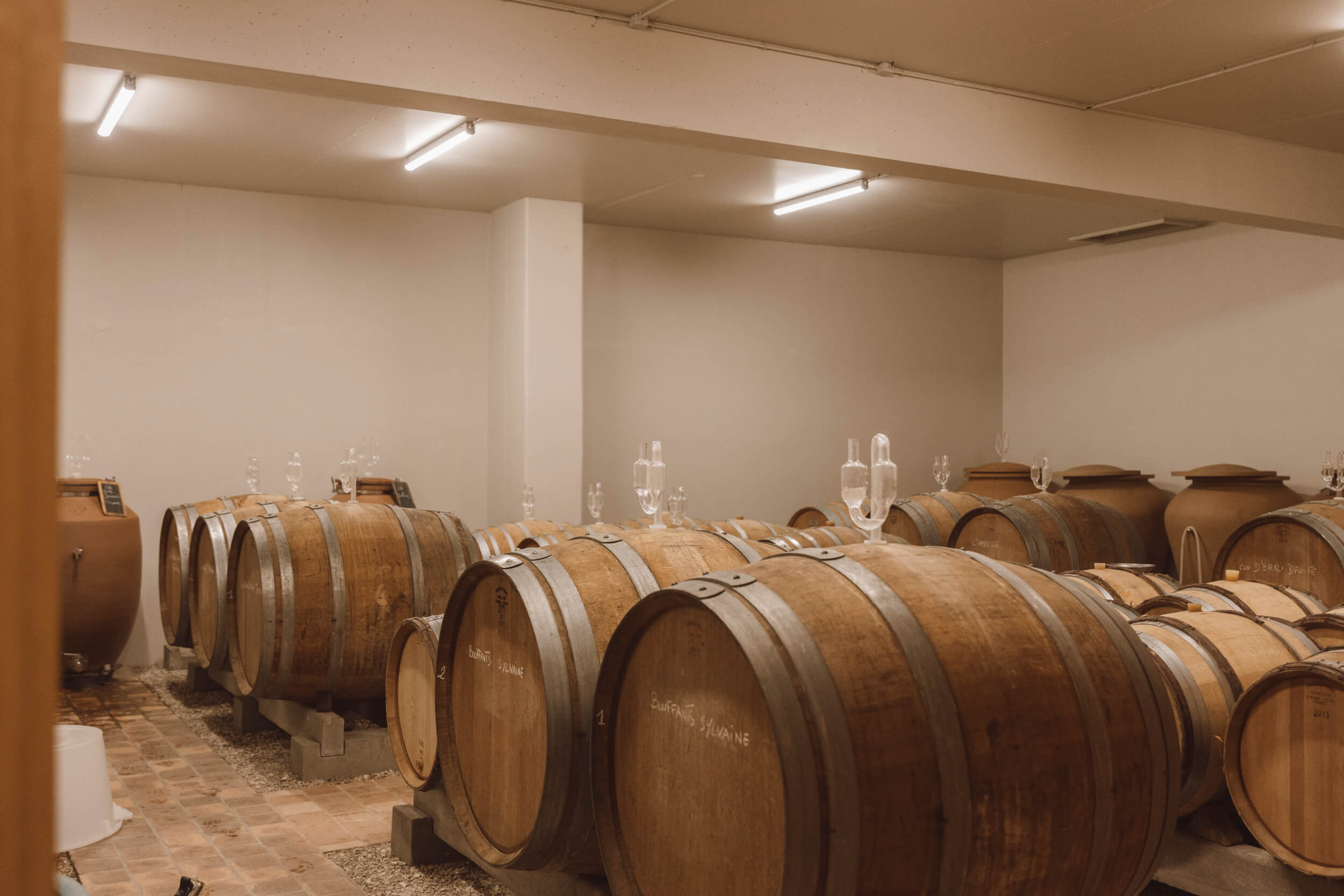 Chai de vieillissement Hubert Brochard avec rangées de barriques en bois destinées à l’élevage des vins de Sancerre.